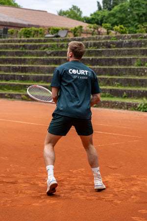 COURT7 Athlet trägt AD-IN Tee Green 200 in Green on-court — T-Shirt