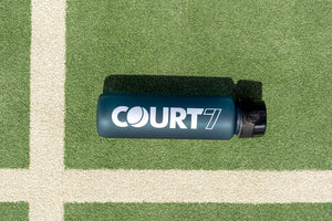 COURT7 Athlet trägt COURT7 Sportflasche in Blau on-court — Sportflasche